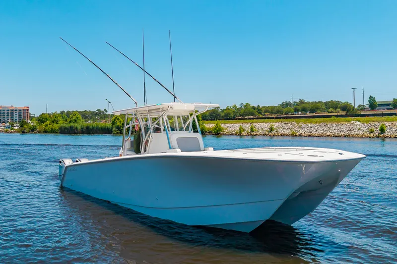 Slide: The Image of A 2022 SeaHunter 38 CTS boat on calm waters with three fishing rods. - 36
