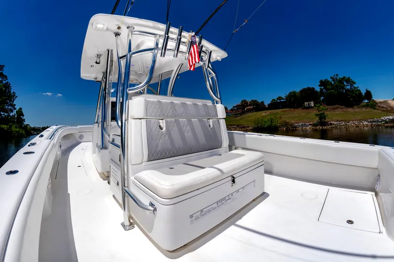 Slide: The Image of A 2022 SeaHunter 38 CTS with a spacious white deck and cushioned seating bench. - 21