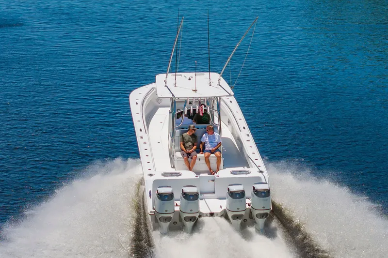 Slide: The Image of A white 2022 SeaHunter 38 CTS boat speeds across the water, featuring four outboard engines. - 45