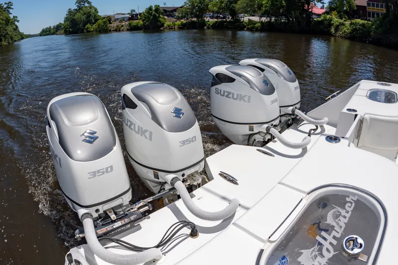 Slide: The Image of A 2022 SeaHunter 38 CTS with four Suzuki 350 HP outboard engines on a river. - 19