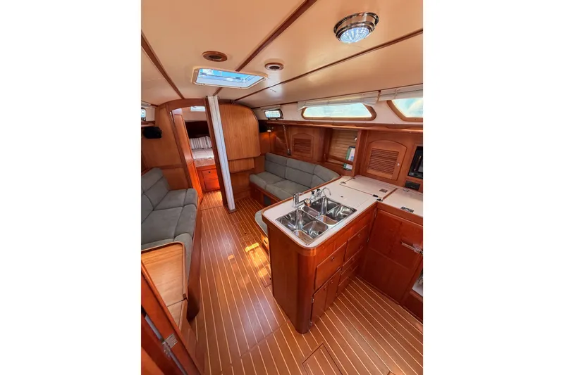 Slide: The Image of Interior of 2002 Sabre 362 sailboat featuring wood finish, cozy seating, and compact kitchen area. - 61