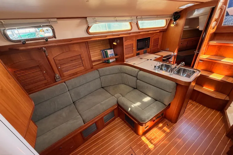 Slide: The Image of Interior of 2002 Sabre 362 yacht with cozy seating, wooden cabinetry, and compact kitchen area. - 85