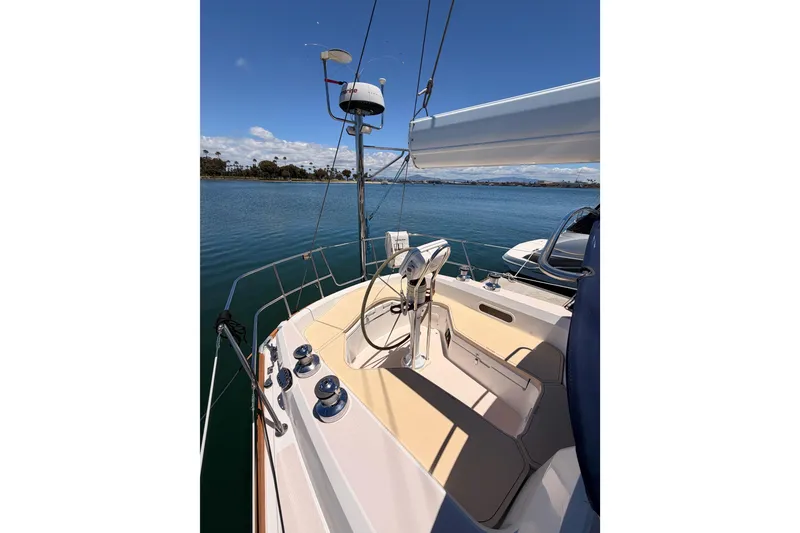 Slide: The Image of 2002 Sabre 362 sailboat cockpit with steering wheel, docked on calm water under blue sky. - 27