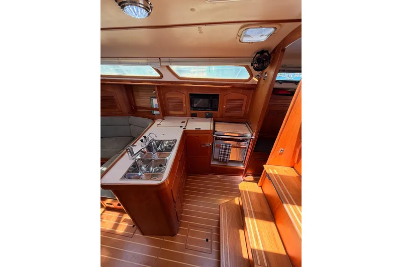 Slide: The Image of Interior of 2002 Sabre 362 sailboat featuring a well-equipped galley with wood finishes. - 43