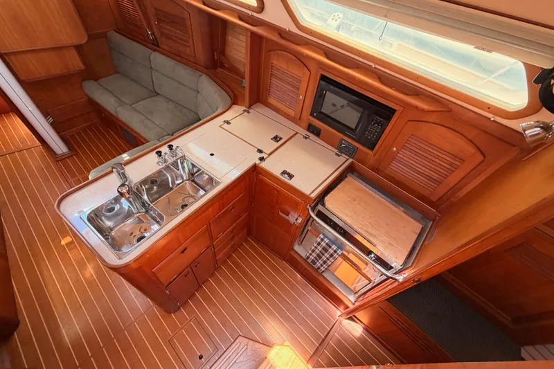 Slide: The Image of Interior of 2002 Sabre 362 yacht featuring a compact kitchen with wood finish. - 41