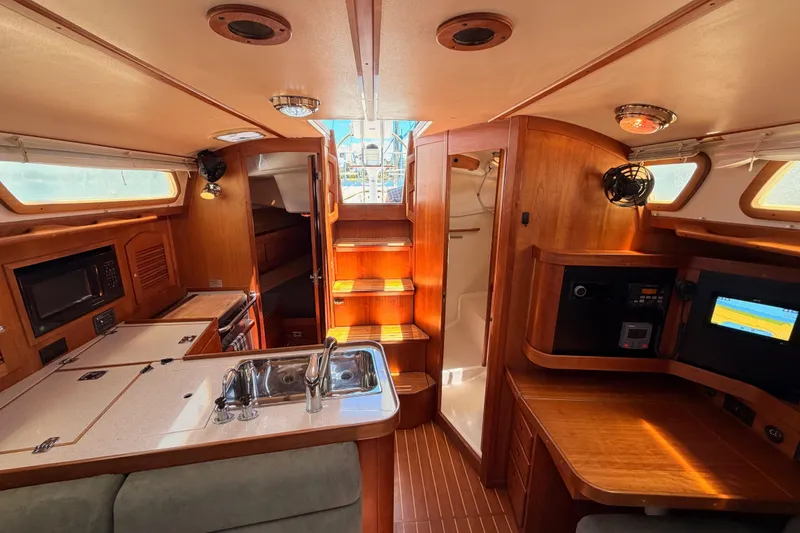 Slide: The Image of Interior of 2002 Sabre 362 sailboat featuring kitchen, seating, and navigation area. - 86