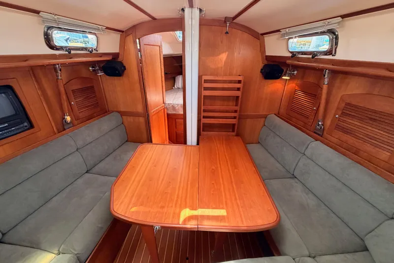Slide: The Image of Interior of 2002 Sabre 362 sailboat with wooden table and cushioned seating. - 66