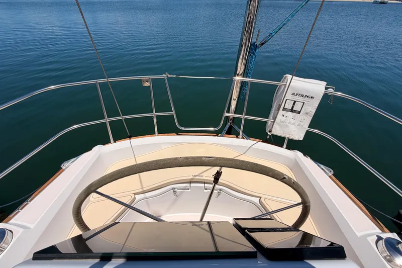 Slide: The Image of Cockpit view of 2002 Sabre 362 sailboat with steering wheel and Lifesling over calm water. - 29