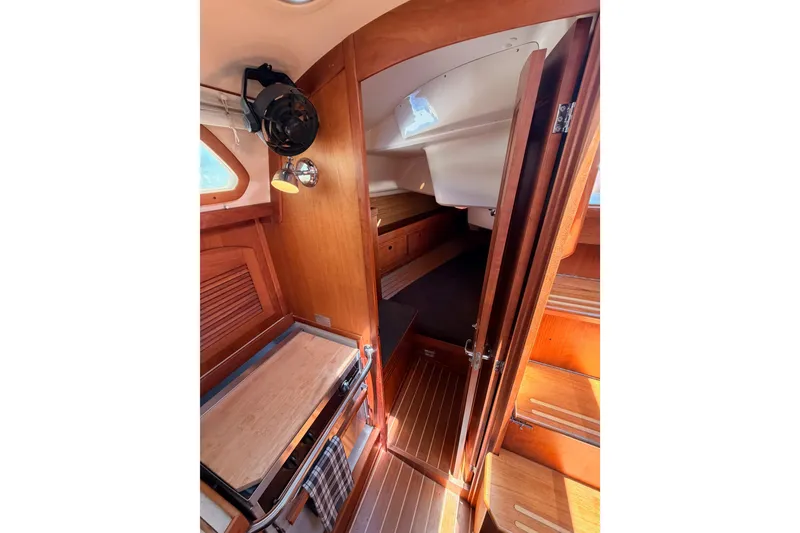 Slide: The Image of Interior of 2002 Sabre 362 sailboat, featuring wooden cabinetry and cozy sleeping quarters. - 51