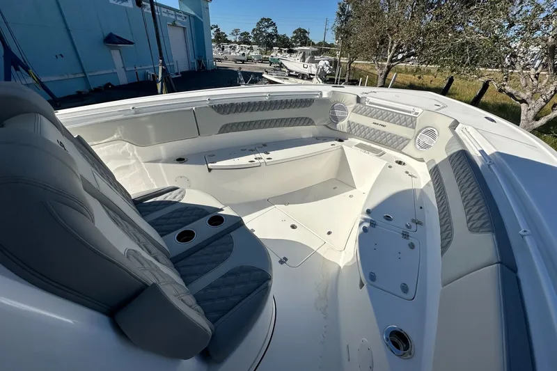 Slide: The Image of 2025 Sea Pro 322 Offshore boat interior with cushioned seating and cup holders. - 8
