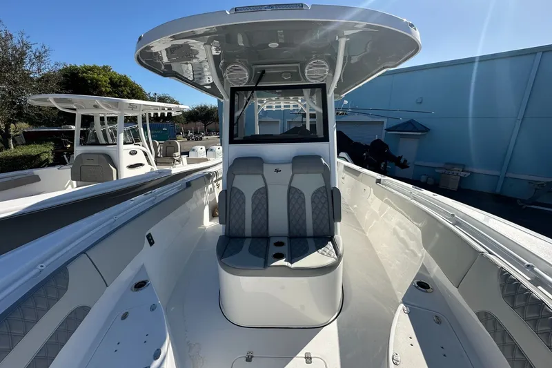 Slide: The Image of 2025 Sea Pro 322 Offshore boat interior with seating and console, docked outdoors. - 10