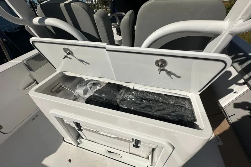 Slide: The Image of 2025 Sea Pro 322 Offshore boat storage compartment with open lid and secured contents. - 19