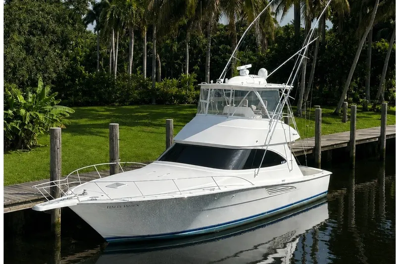 The Image of 2019 Viking 44 Convertible yacht docked by lush greenery and palm trees. - 0