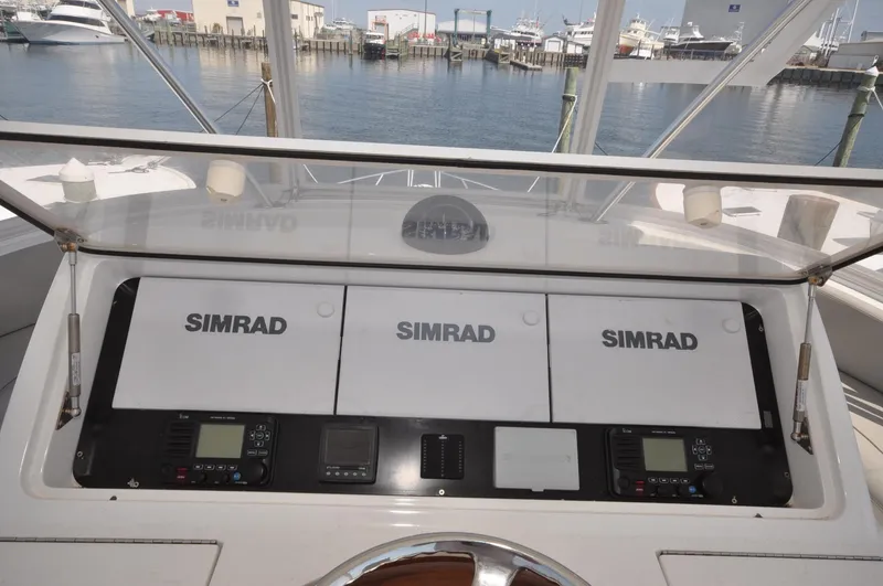 Slide: The Image of 2019 Viking 44 Convertible yacht helm with Simrad navigation system, docked at marina. - 15