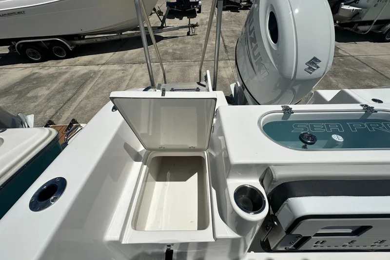 Slide: The Image of 2026 Sea Pro 222 Center Console boat with open storage compartment and Suzuki engine. - 13