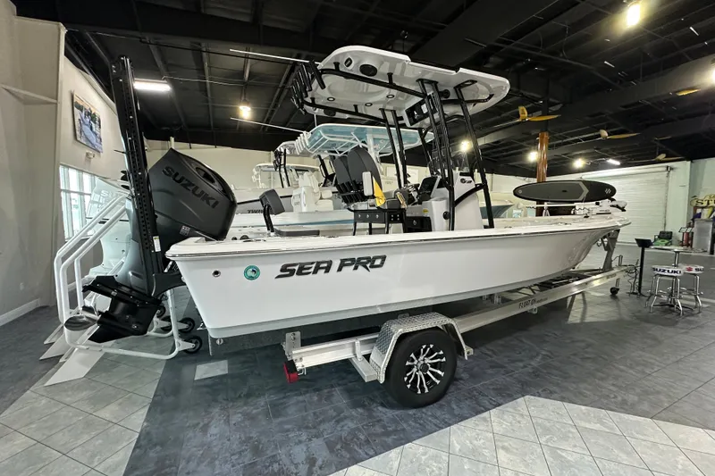 Slide: The Image of 2026 Sea Pro 230 Bay boat displayed indoors on a trailer. - 2