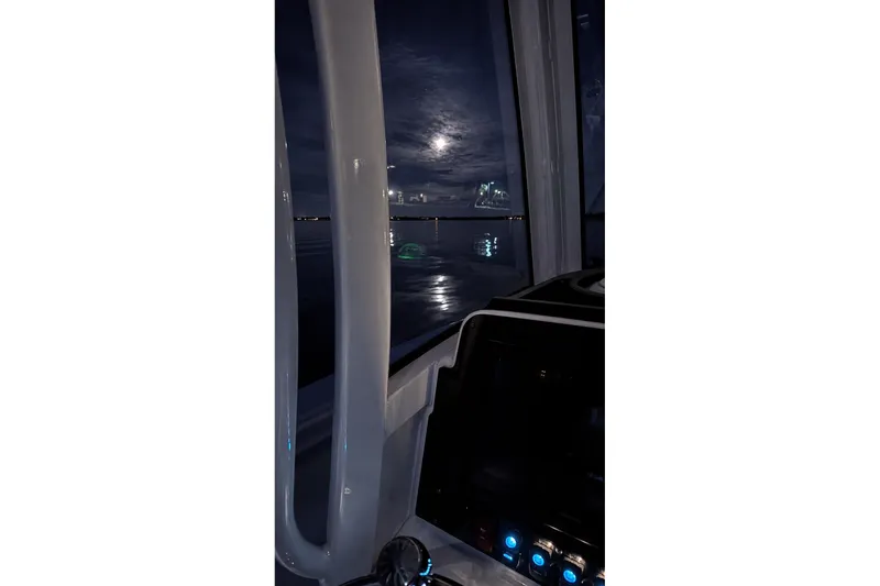 Slide: The Image of Night view from a 2022 Sea Hunt Gamefish 27FS boat, moonlit water visible. - 14