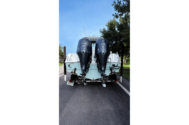 Slide: The Image of 2022 Sea Hunt Gamefish 27FS with dual outboard motors on a road. - 35