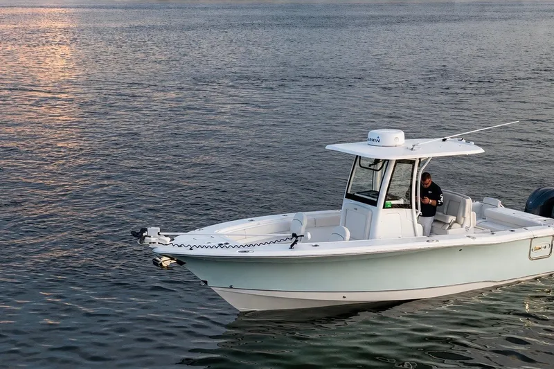 Slide: The Image of 2022 Sea Hunt Gamefish 27FS boat on calm water at sunset. - 1