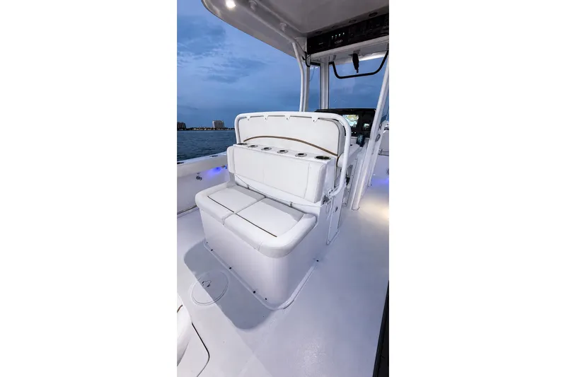 Slide: The Image of 2022 Sea Hunt Gamefish 27FS boat interior with cushioned seating and cup holders. - 31