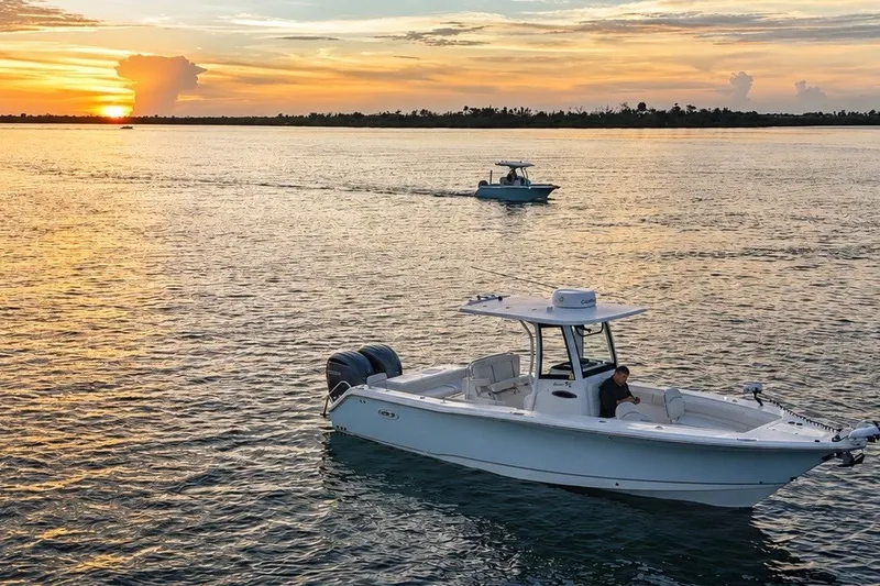 Slide: The Image of 2022 Sea Hunt Gamefish 27FS boat on water at sunset. - 7