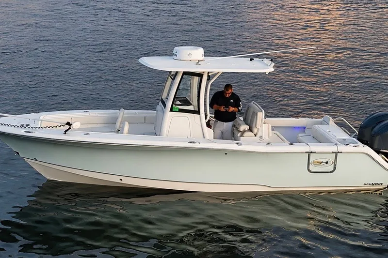 Slide: The Image of 2022 Sea Hunt Gamefish 27FS boat on calm water at sunset. - 6