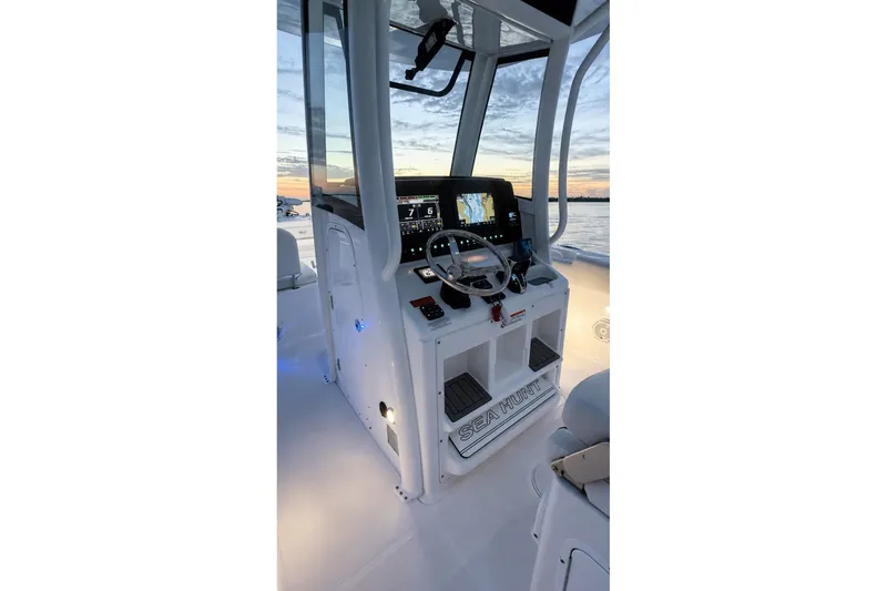Slide: The Image of 2022 Sea Hunt Gamefish 27FS boat console with navigation equipment at sunset. - 20
