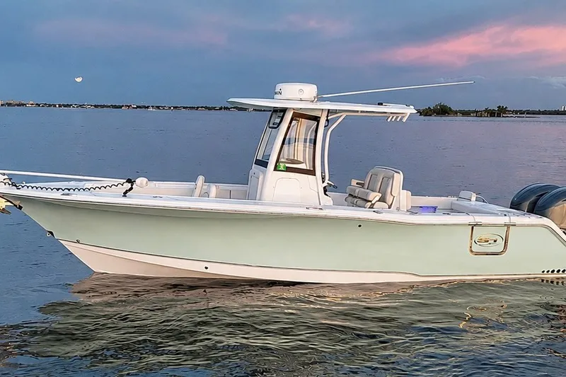 Slide: The Image of 2022 Sea Hunt Gamefish 27FS boat on calm water at sunset. - 5