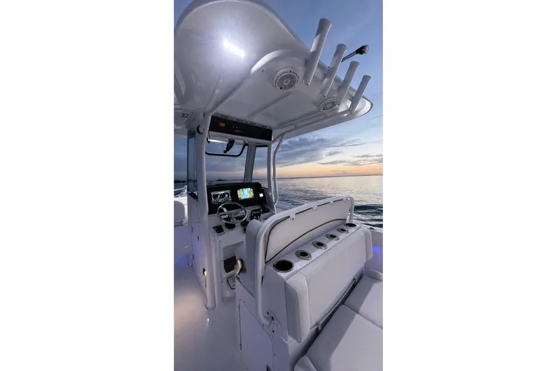 Slide: The Image of 2022 Sea Hunt Gamefish 27FS boat interior at sunset, featuring helm and seating. - 23