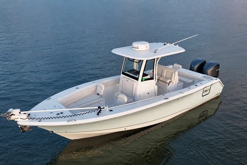 Slide: The Image of 2022 Sea Hunt Gamefish 27FS boat on calm water, featuring dual engines and spacious seating. - 3