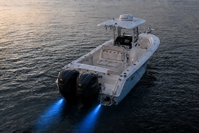 Slide: The Image of 2022 Sea Hunt Gamefish 27FS boat with dual Yamaha engines on water at sunset. - 12