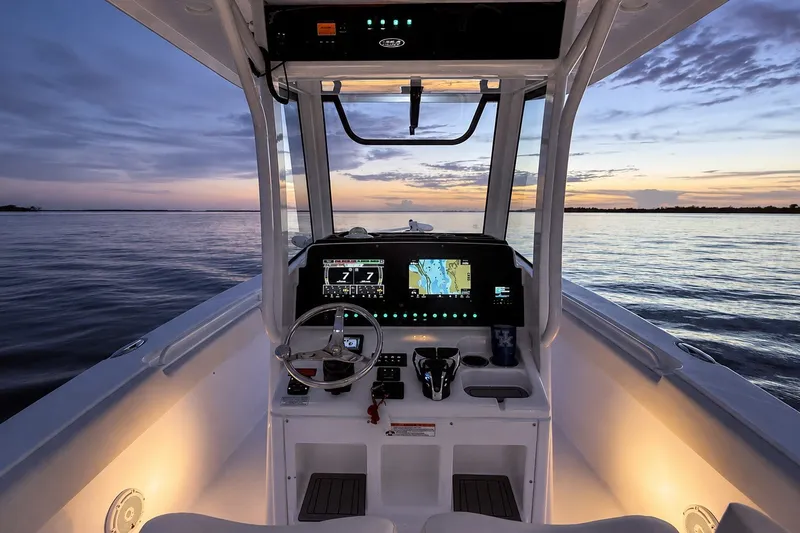 Slide: The Image of 2022 Sea Hunt Gamefish 27FS boat console at sunset on calm waters. - 19