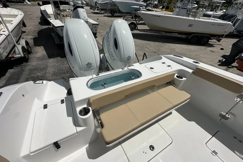 Slide: The Image of 2026 Sea Pro 262 Offshore boat with dual engines and beige seating in a marina. - 12