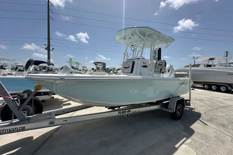 Slide: The Image of 2026 Sea Pro 202 Center Console boat on trailer under clear blue sky. - 1