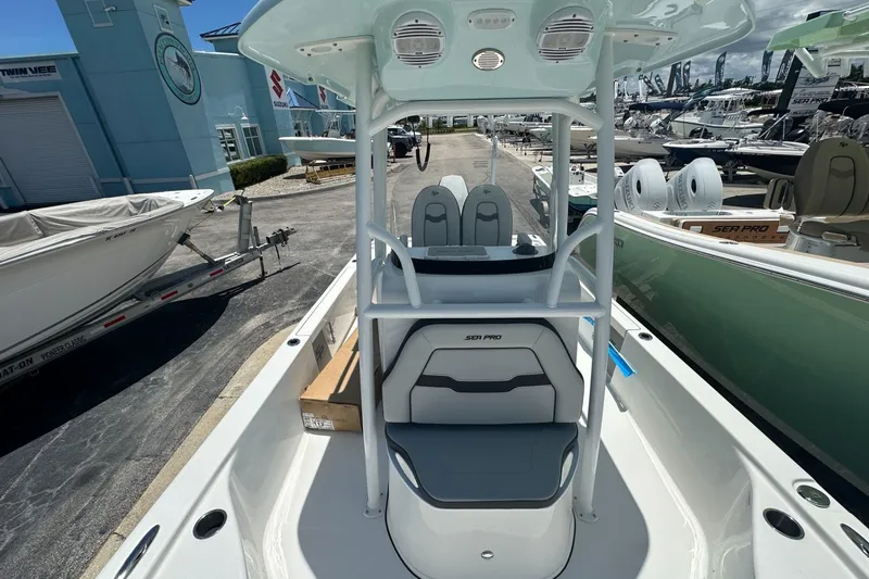 Slide: The Image of 2026 Sea Pro 250 Bay boat interior at a marina, showcasing seating and console. - 8