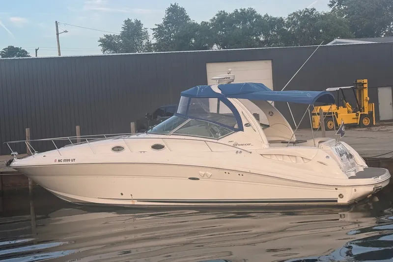 Slide: The Image of 2007 Sea Ray 340 Sundancer docked with blue cover and calm water. - 1