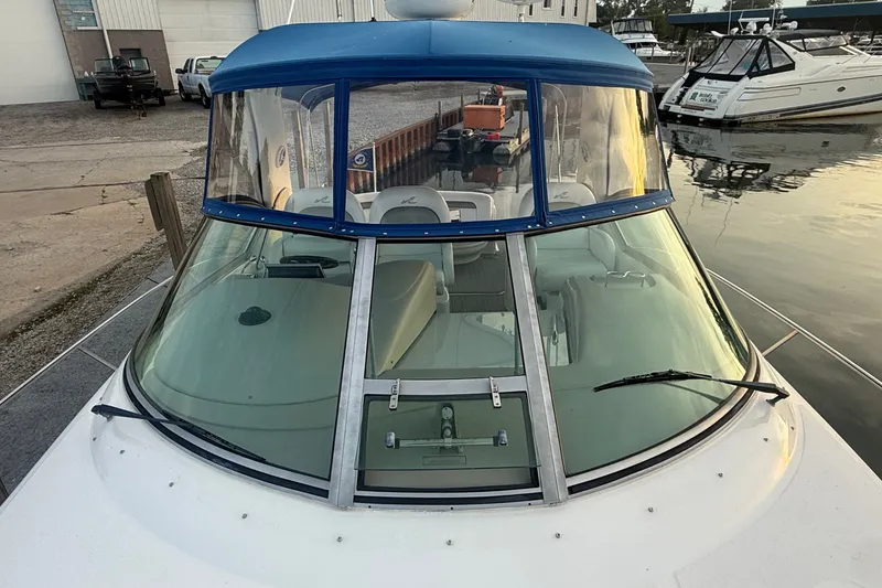 Slide: The Image of 2007 Sea Ray 340 Sundancer boat docked, featuring blue canopy and spacious cockpit. - 6