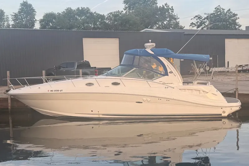Slide: The Image of A 2007 Sea Ray 340 Sundancer docked. It features a blue canopy. - 0