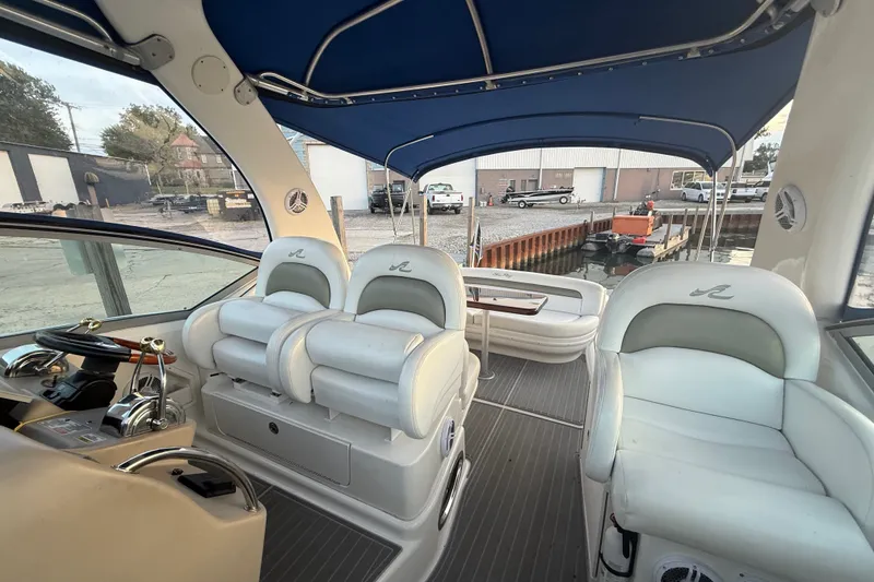 Slide: The Image of Interior of a 2007 Sea Ray 340 Sundancer boat with white seating and blue canopy. - 16