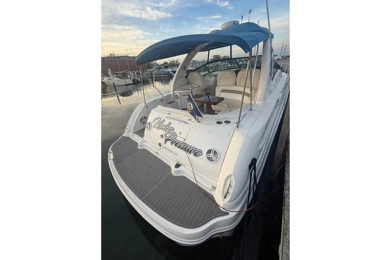 Slide: The Image of 2007 Sea Ray 340 Sundancer yacht docked, featuring a blue canopy and spacious seating area. - 3