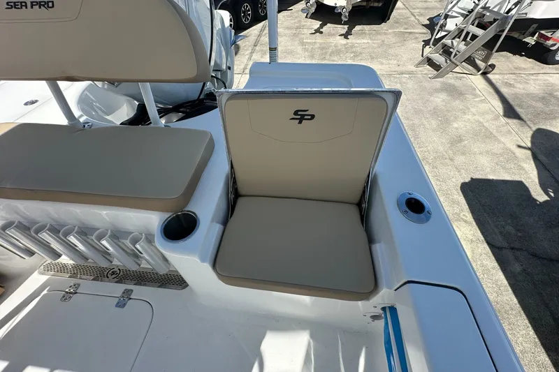 Slide: The Image of 2026 Sea Pro 230 Bay boat seating area with rod holders and cup holder. - 12