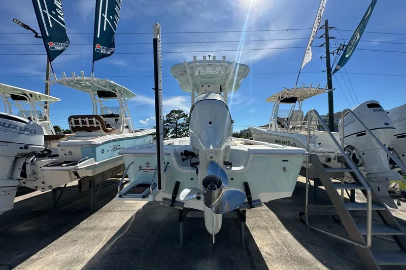 Slide: The Image of 2026 Sea Pro 230 Bay boat displayed outdoors with other boats under clear blue sky. - 2
