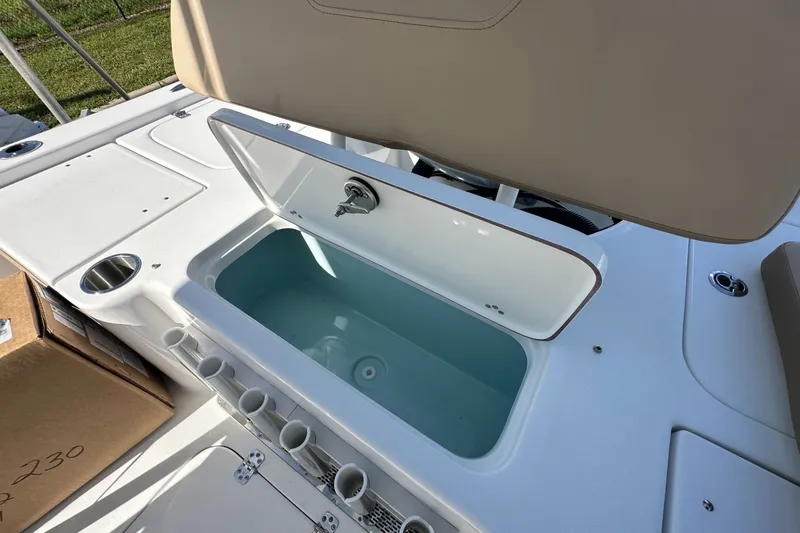 Slide: The Image of 2026 Sea Pro 230 Bay boat with open storage compartment and rod holders. - 13