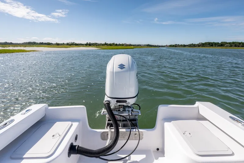 Slide: The Image of 1980 Sea Ox 230 Center Console boat on calm water with outboard motor. - 27
