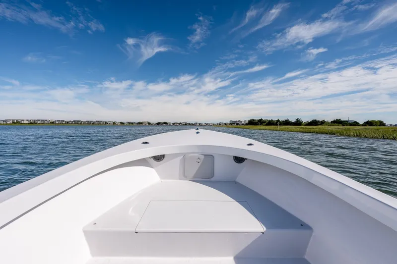 Slide: The Image of 1980 Sea Ox 230 Center Console boat cruising on a calm lake under a clear blue sky. - 23