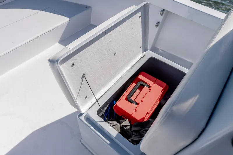 Slide: The Image of Open storage compartment on 1980 Sea Ox 230 Center Console boat with red toolbox inside. - 28