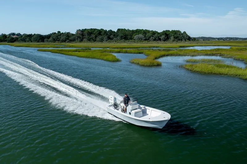 Slide: The Image of 1980 Sea Ox 230 Center Console boat cruising through scenic marshland waters. - 15