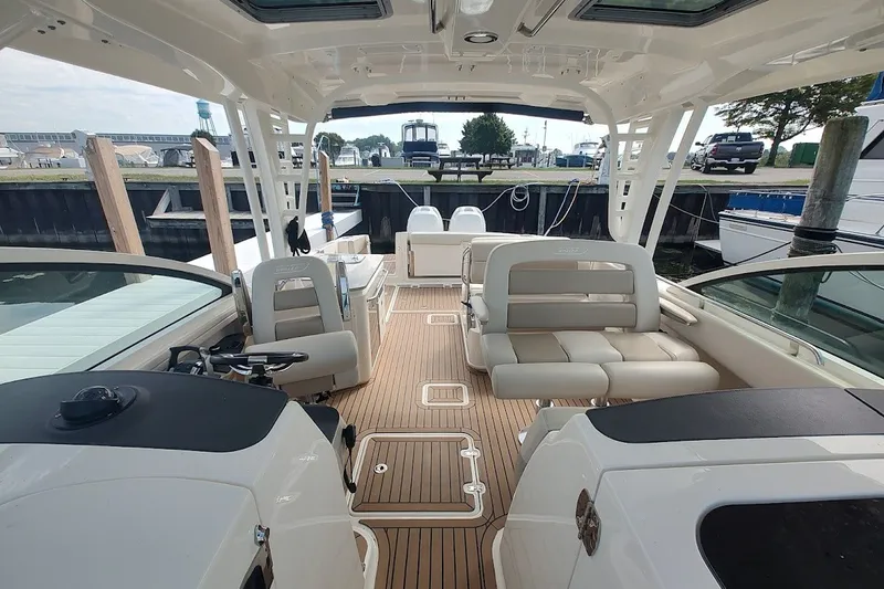 Slide: The Image of 2018 Boston Whaler 320 Vantage boat interior with seating and helm, docked at marina. - 56