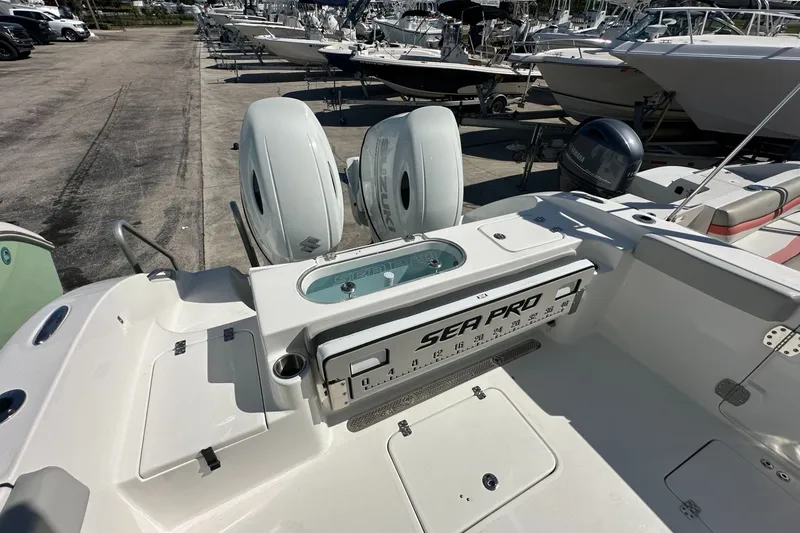 Slide: The Image of 2026 Sea Pro 262 Offshore boat with dual engines, docked among other boats. - 14