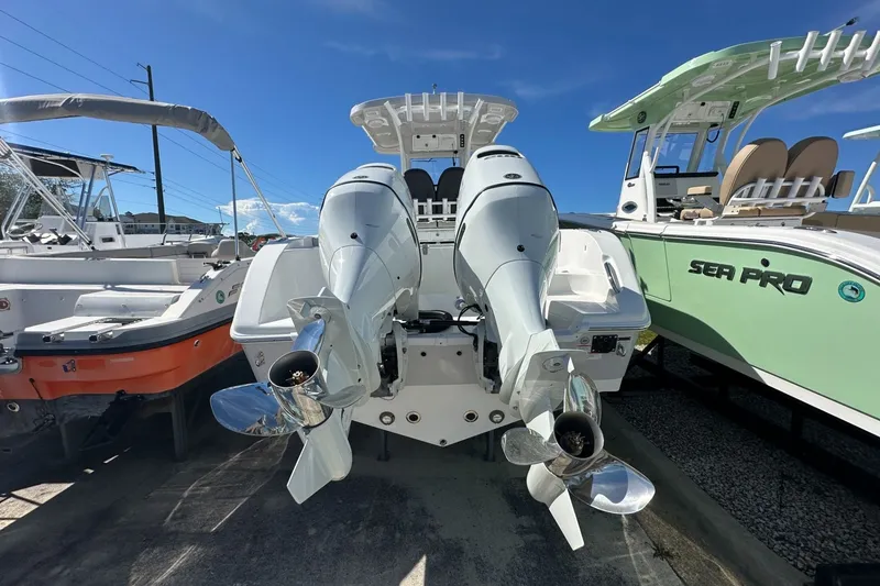 Slide: The Image of 2026 Sea Pro 262 Offshore boat with dual outboard motors, docked under clear blue sky. - 2
